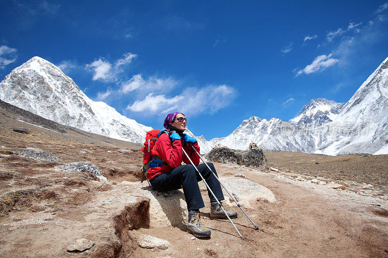 女登山运动员坐在山上欣赏风景