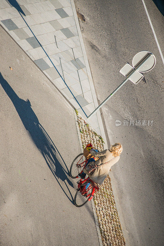 在城市里骑自行车的老妇人