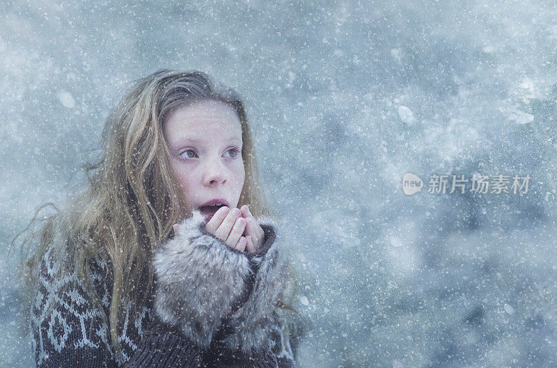 女孩试图让手指在暴风雪中保持温暖