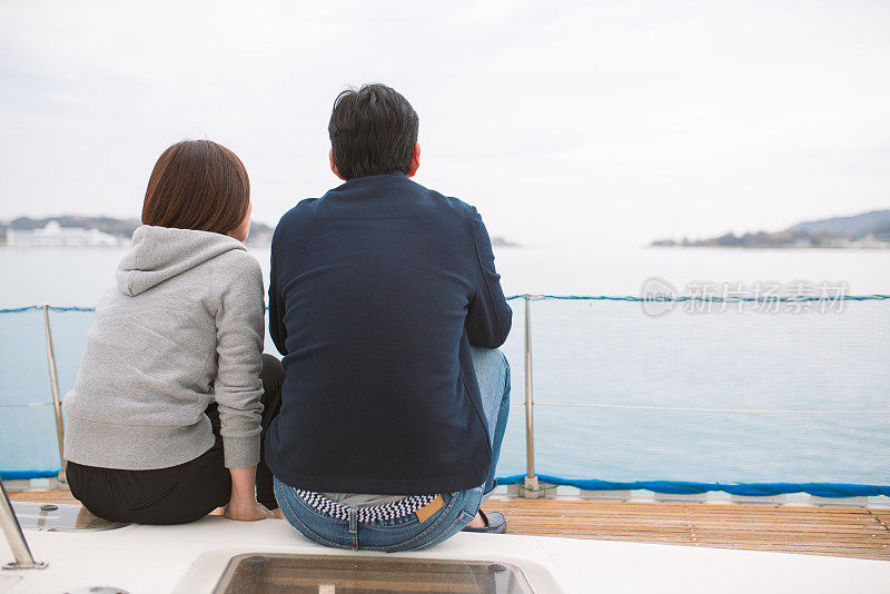一对夫妇坐在豪华游艇上眺望大海