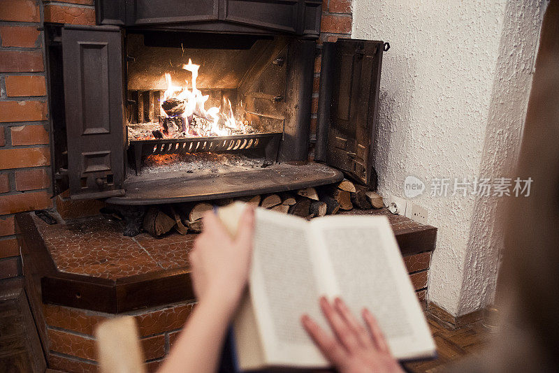 女人在壁炉旁看书