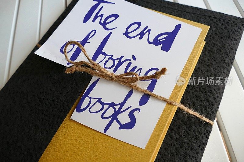 用绳子把书裹起来，上面写着文字:枯燥的书结束了