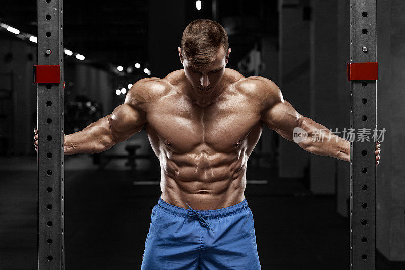 性感肌肉男在健身房，塑形腹部。强壮的男性裸体躯干腹肌，锻炼