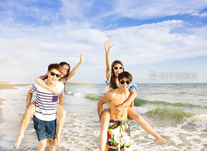 在海滩上奔跑的快乐青年团体