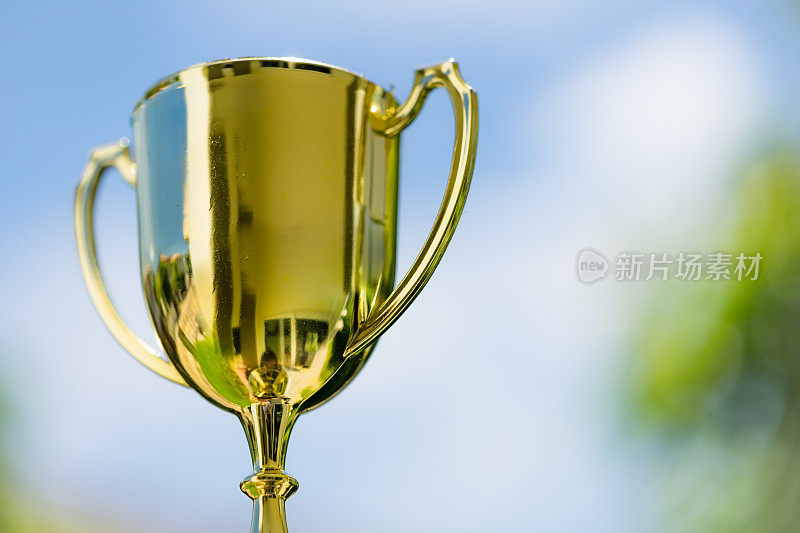 金色奖杯与蓝天背景与复制空间作为获胜者奖励或奖励概念