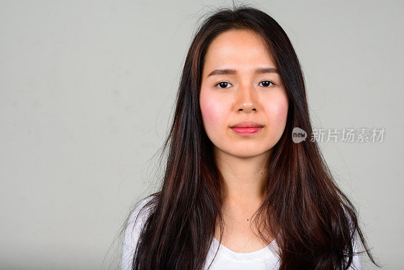 年轻美丽的亚洲女人长直发对抗白色的背景