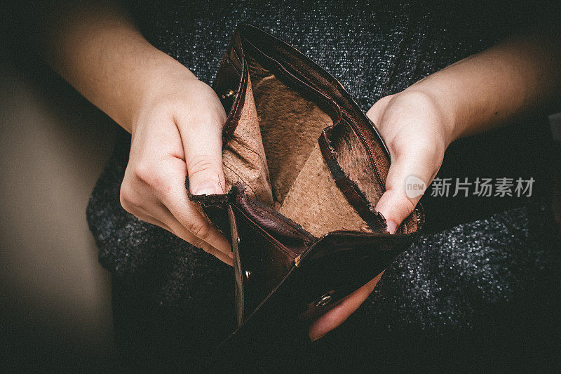 手里拿着一个旧的空钱包，女人手里拿着一个复古的空钱包。贫困概念,退休。特殊的爽肤水