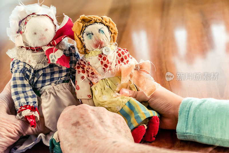 年长妇女手握旧自制缝制娃娃