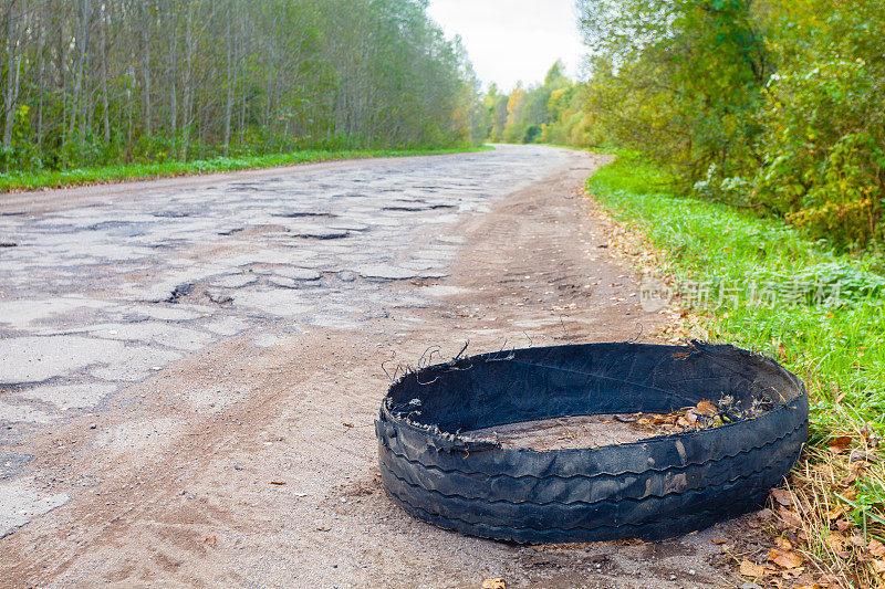 轮胎被毁的橡胶车行驶在崎岖不平的乡村公路上