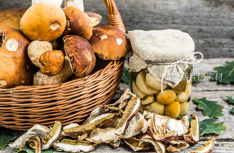 罐子里腌制的香菇和乡村背景上的干蘑菇，秋天的蜜饯准备