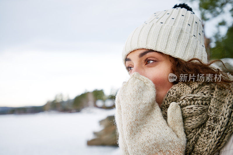 沉思的女人在冬天吹手