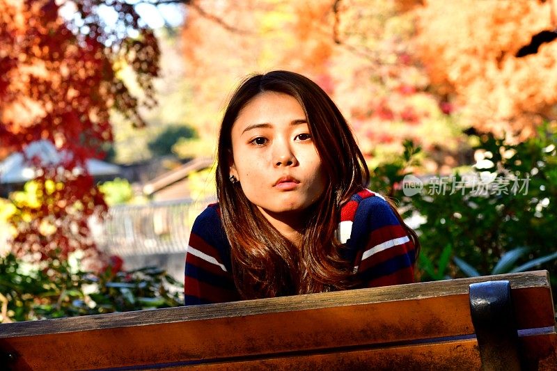 年轻的日本女子在公园做各种面部表情