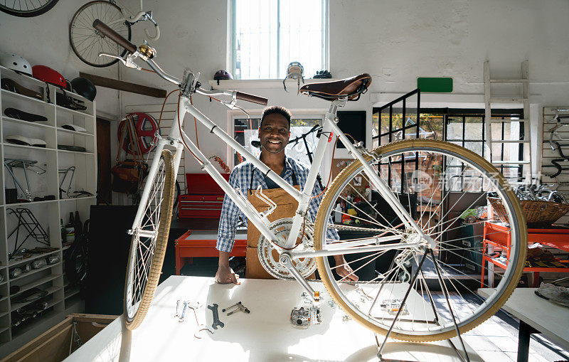 一个黑人站在一辆老式自行车后微笑的肖像