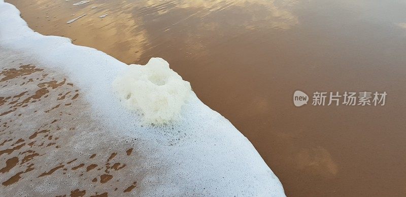 泡沫状的白色海浪拍打着海滩