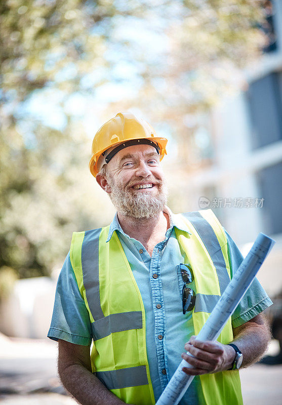 戴着安全帽的成熟男性建筑工人微笑着