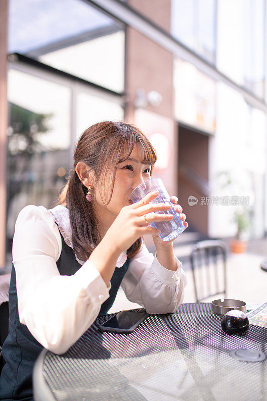 年轻女子坐在露天咖啡馆吃午饭