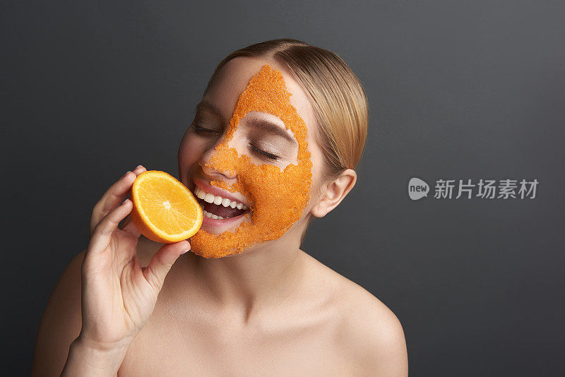 快乐的女士，微笑着咬着橘子片