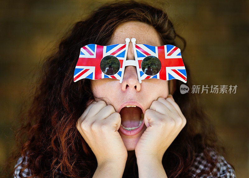 戴着英国国旗太阳镜的年轻女子吓坏了