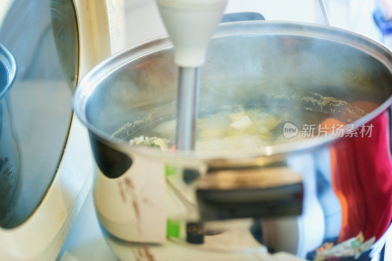 西兰花奶油汤准备，蔬菜用搅拌器切碎，特写