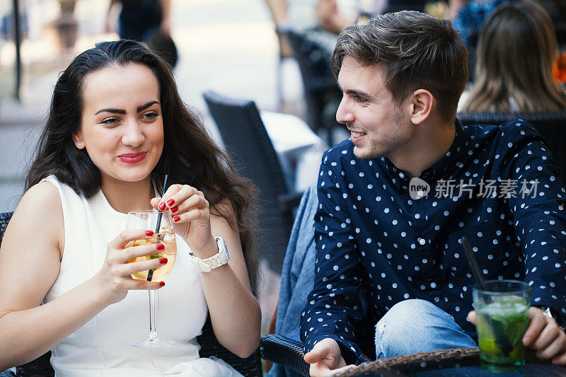 年轻的夫妇笑着喝着鸡尾酒