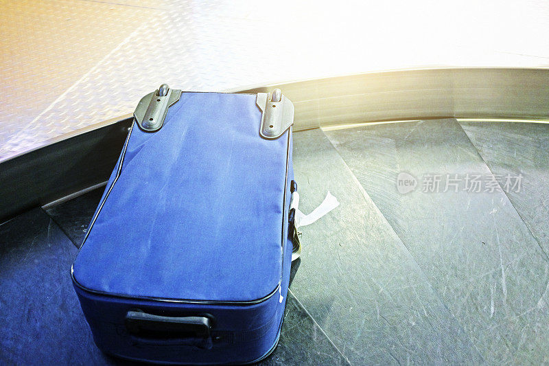 机场行李传送带上的轮式行李箱