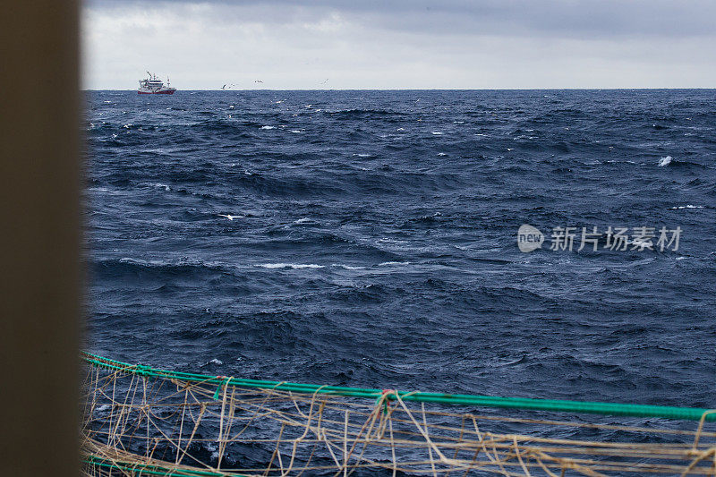 在波涛汹涌的海面上出海的拖网渔船