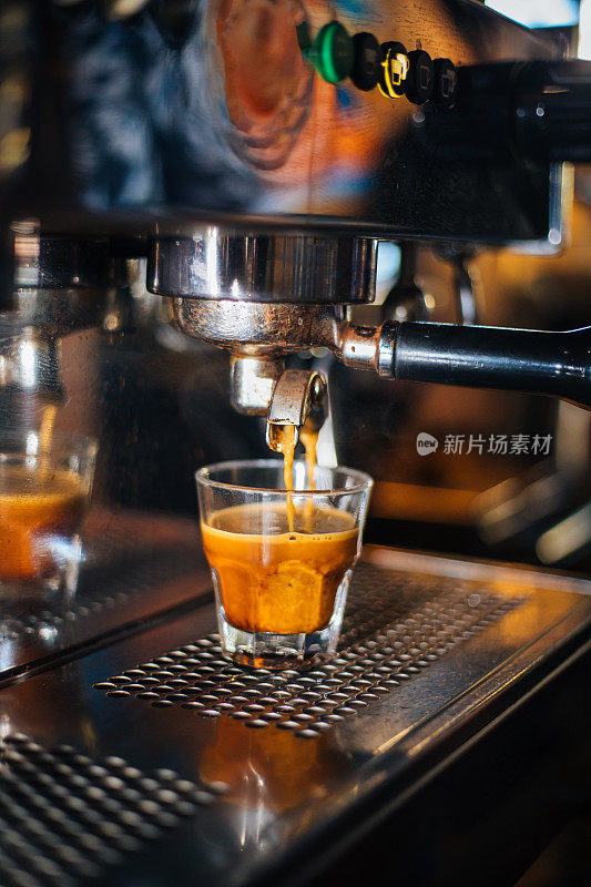 咖啡馆里的浓缩咖啡机正在倾倒新鲜煮好的咖啡
