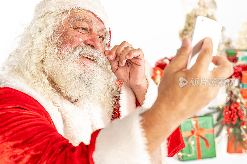 圣诞老人对着他的手机摄像头微笑