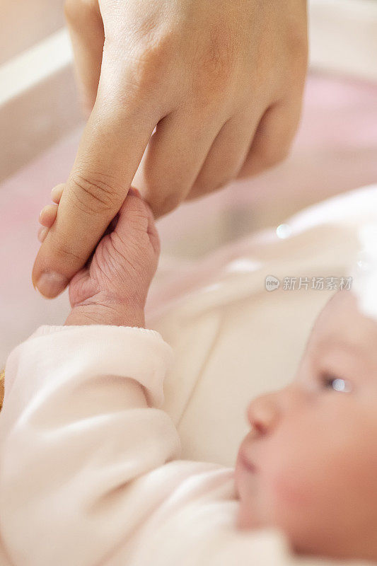 婴儿牵着母亲的手