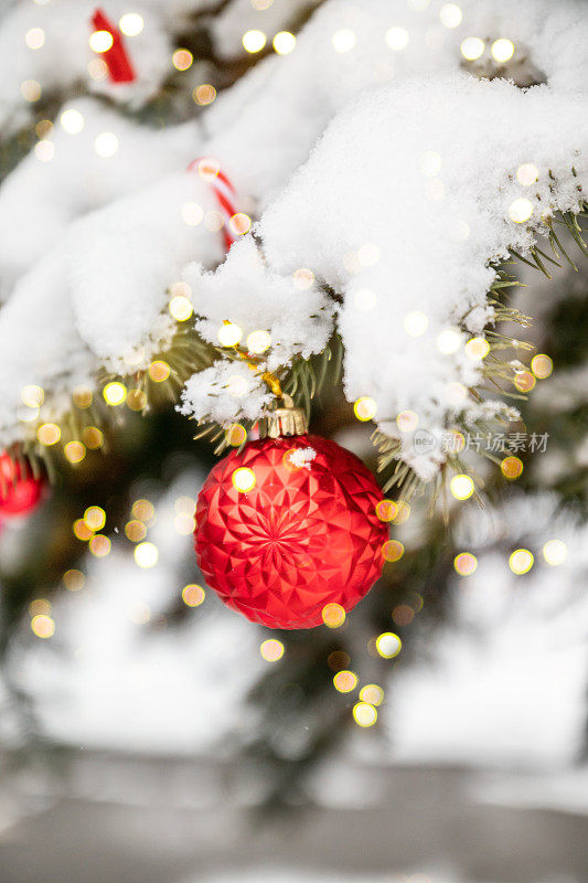 圣诞快乐和节日快乐贺卡或横幅，装饰红色玩具球和雪圣诞树。新年。焦外成像模糊的背景