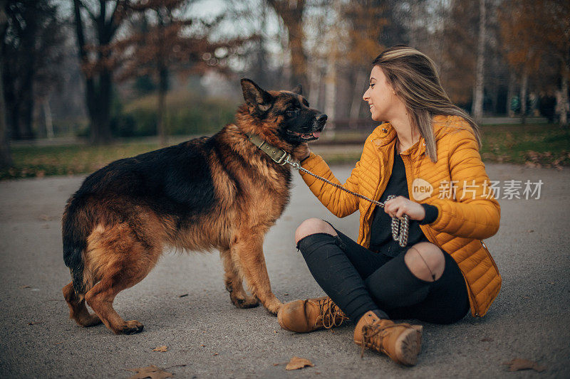 年轻女子和德国牧羊犬在公园里玩