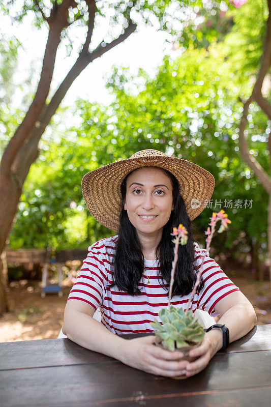 女人捧着开花的肉质植物