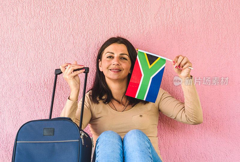 拿着旅行袋和南非国旗的女人