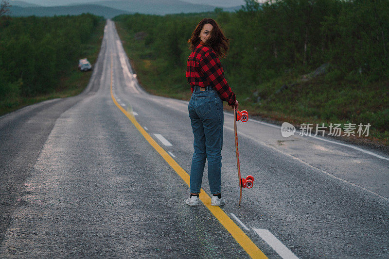 芬兰的一名女子在路上玩长滑板