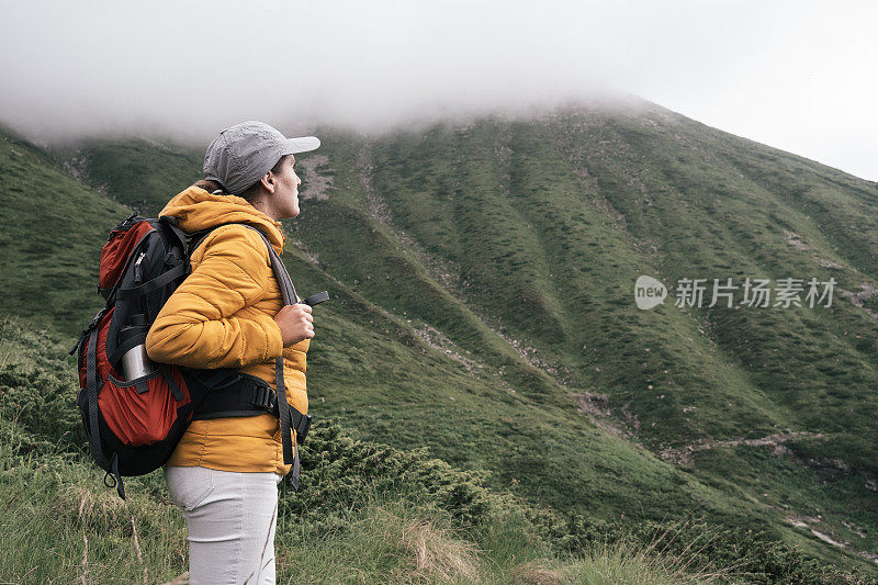 回归自然。独自在山里徒步旅行的女人。2019冠状病毒病大流行后阳光明媚的户外享受。