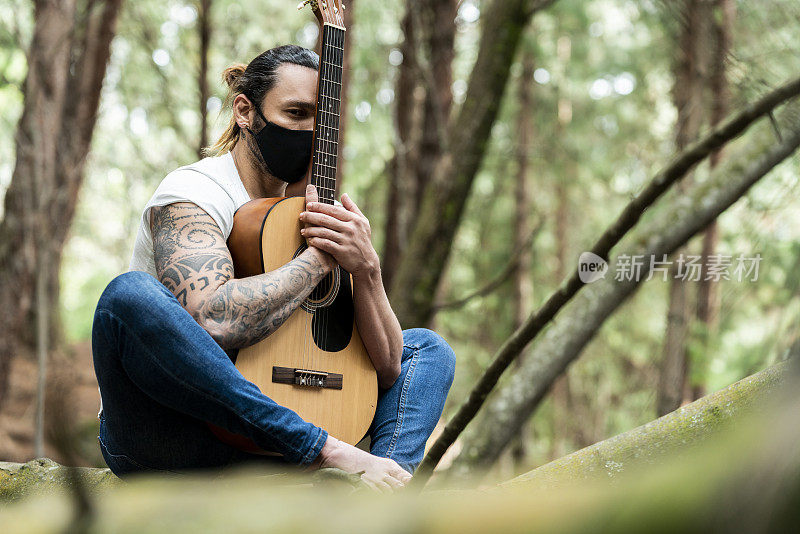 一个拉丁人在森林里独自弹吉他