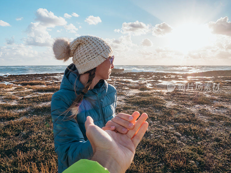 夫妻牵着手在海边，跟我来