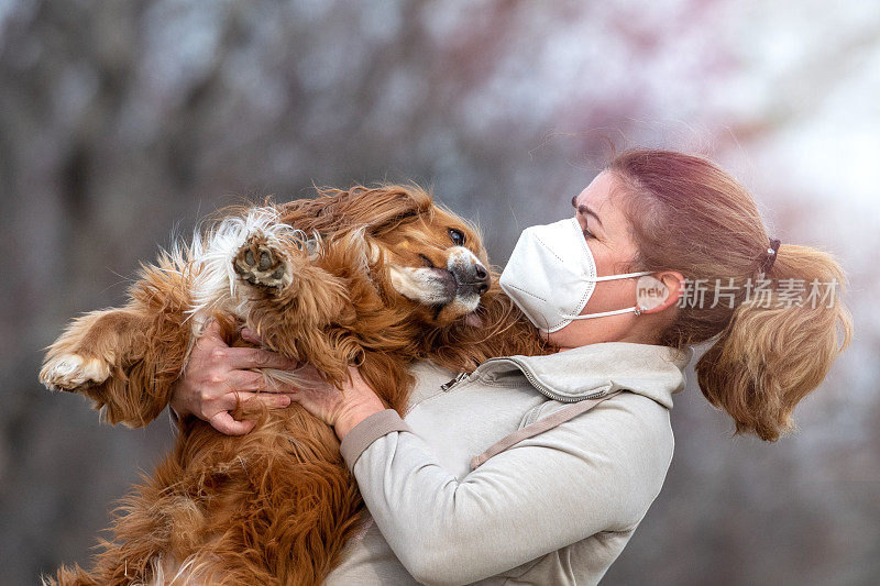 一个成年妇女在外面和她的狗玩