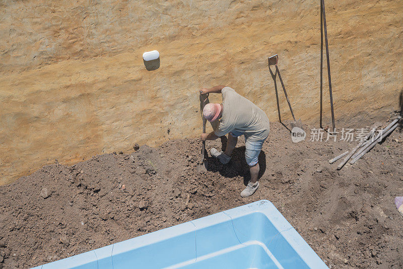 建筑工人在自家后院安装游泳池