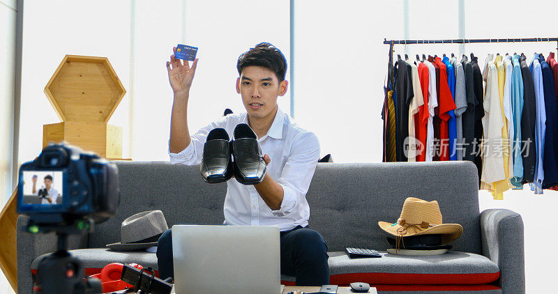 一位亚洲男子在博客上播放一段视频，介绍他在网上销售帽子、鞋子、耳机、衣服、安全头饰等产品。在家购物的概念