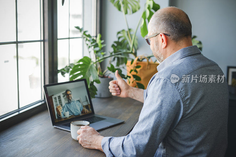 成年男性在家办公(使用笔记本电脑，视频会议)