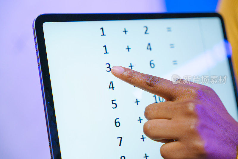 一名年轻教师的手在数码平板电脑上显示数字