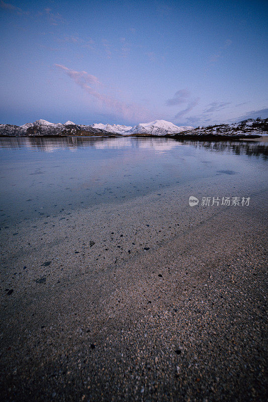 北方的日落。宁静的山景与神奇的粉红色光。阳光反射在海湾的水面上