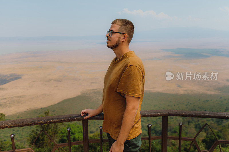 侧面的男性旅行者凝视恩戈罗恩戈罗火山口从上面的观点