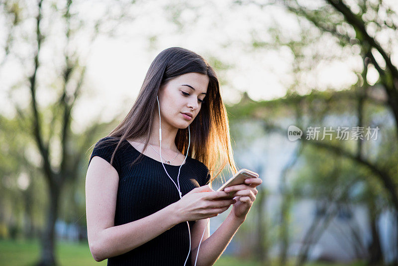 春天里拿着智能手机的年轻女子