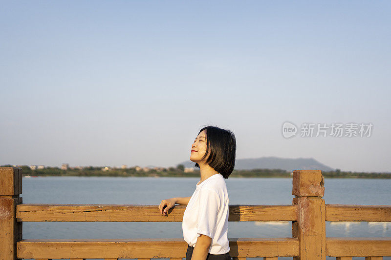 一位亚洲妇女在美丽的河边眺望远方