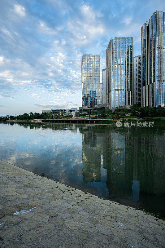 阳光明媚的日子里，沿河有现代化的建筑和桥梁