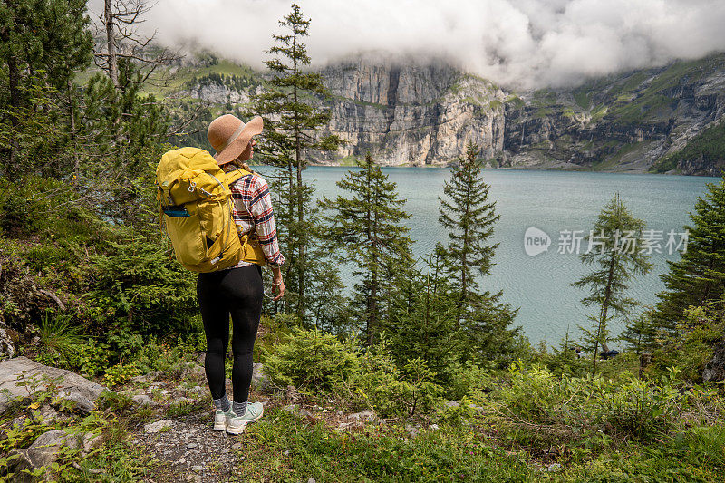 年轻女子徒步旅行在一个美丽的高山风景在夏天散步在瑞士阿尔卑斯山享受自然和户外