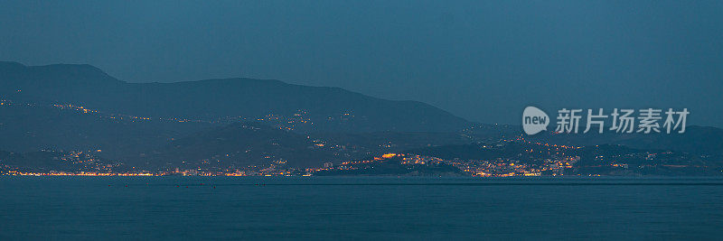 海上夜景照片。在欧洲旅行。意大利。波。海洋风暴。第勒尼安海沿岸。晨曦中有雾。意大利具有里程碑意义的全景。景观。美丽的彩灯