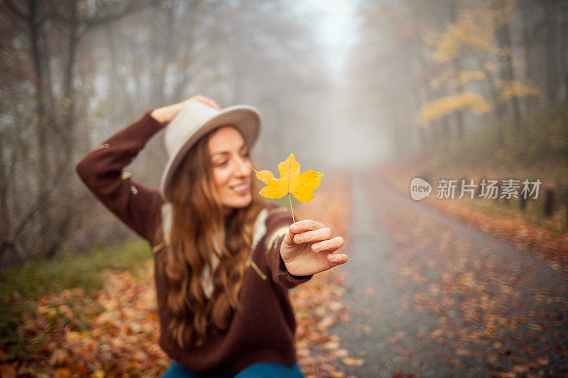 美丽的年轻女子在秋天走在户外的画像